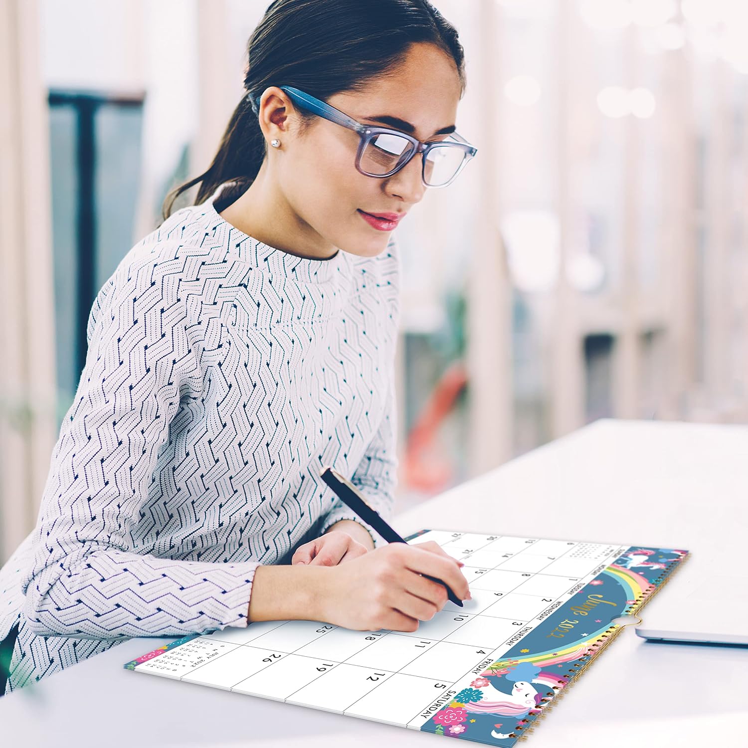 Woman writing her plans on the calendar at a desk
